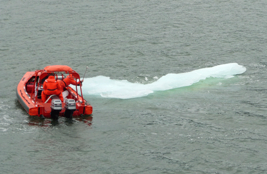 Ferry crewmen hacking at ice berg Petersburg-Kake run