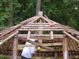 Walter Cooke using sledge hammer to remove skip sheathing on gazebo