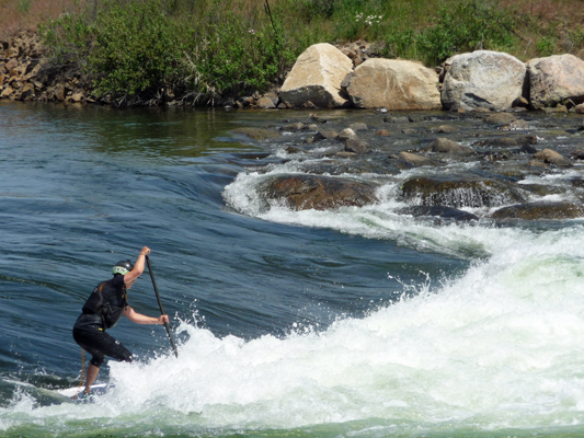 Stand up boarder going down rapid Kellys whitewater park ID