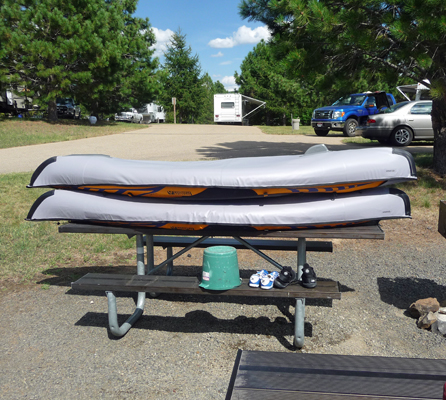 Inflatable kayaks stacked on picnic table
